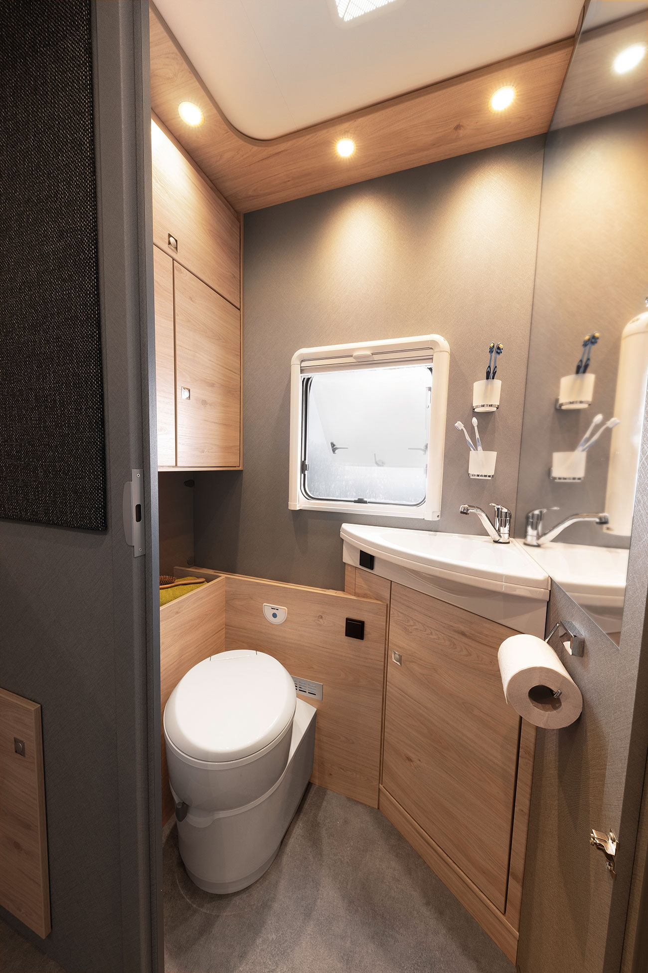 The bathroom is equipped with a large mirror surface that gives both taller and shorter occupants a clear view of themselves. The semi-transparent tinted window and forced-ventilation system in the roof ensure good air flow.